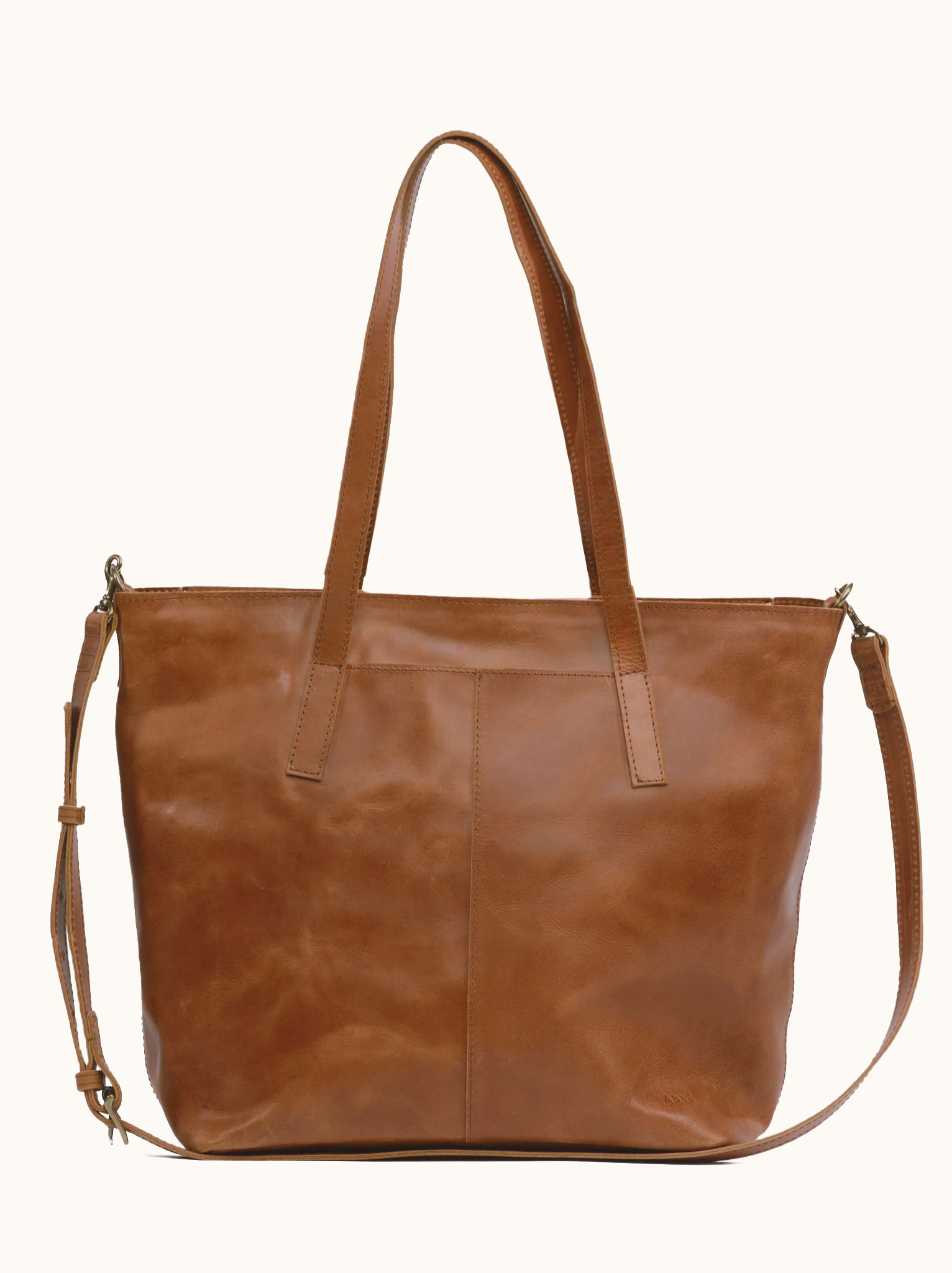 Brown leather tote bag with shoulder and crossbody straps on a white background #Color_Whiskey