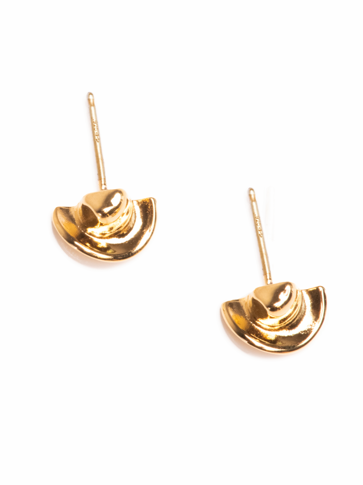 Top view of gold cowboy hat earrings on a white background