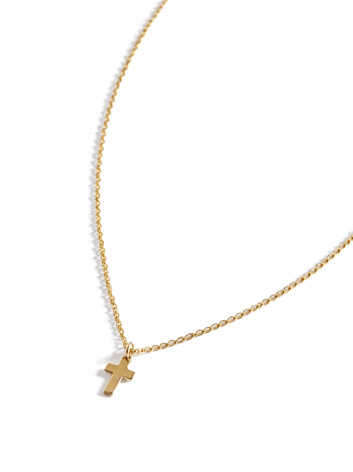 Gold necklace with a cross pendant on a white background.
