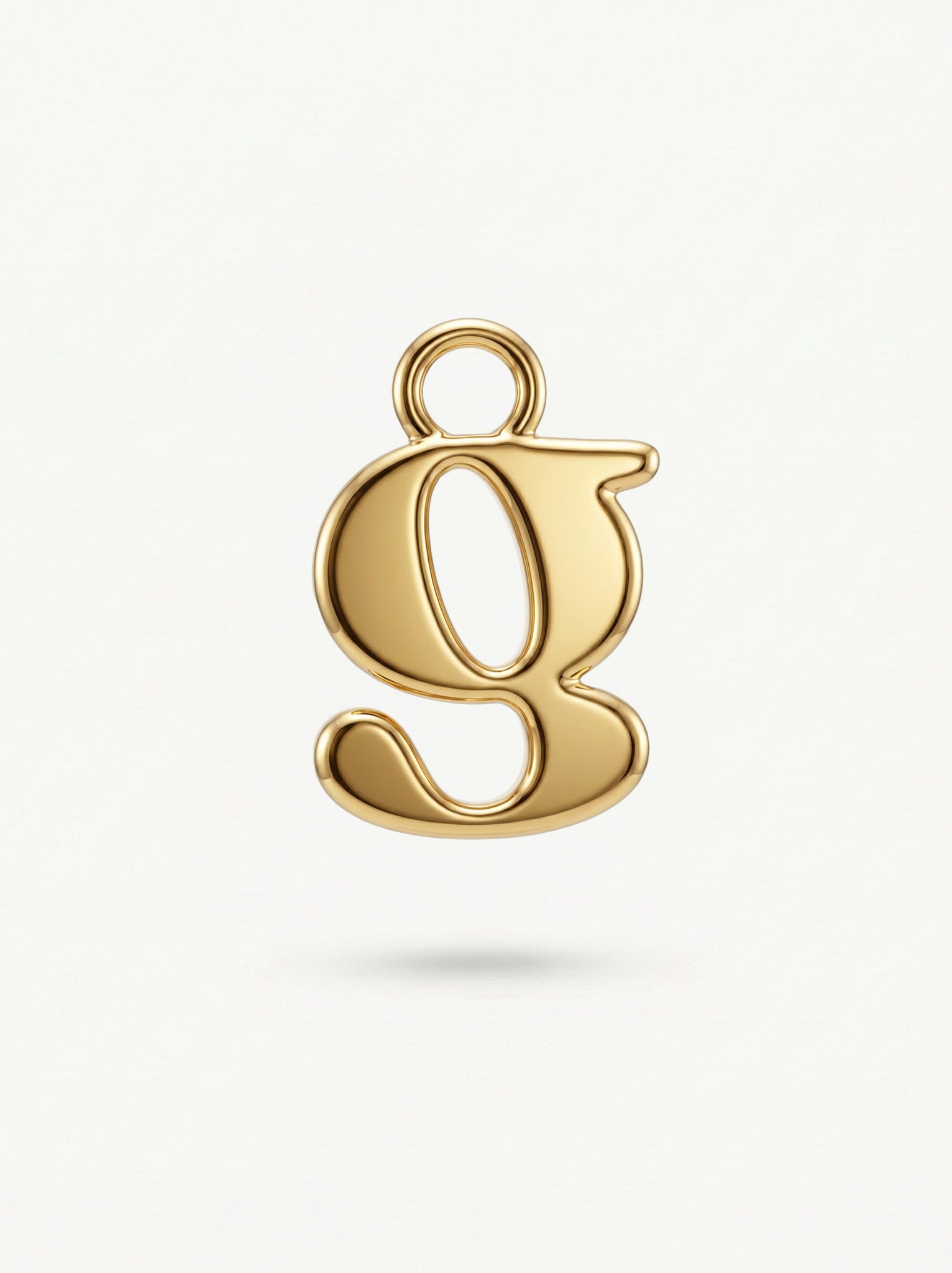 Initial Charm Gold Vermeil; Gold letter 'g' pendant on a light beige background