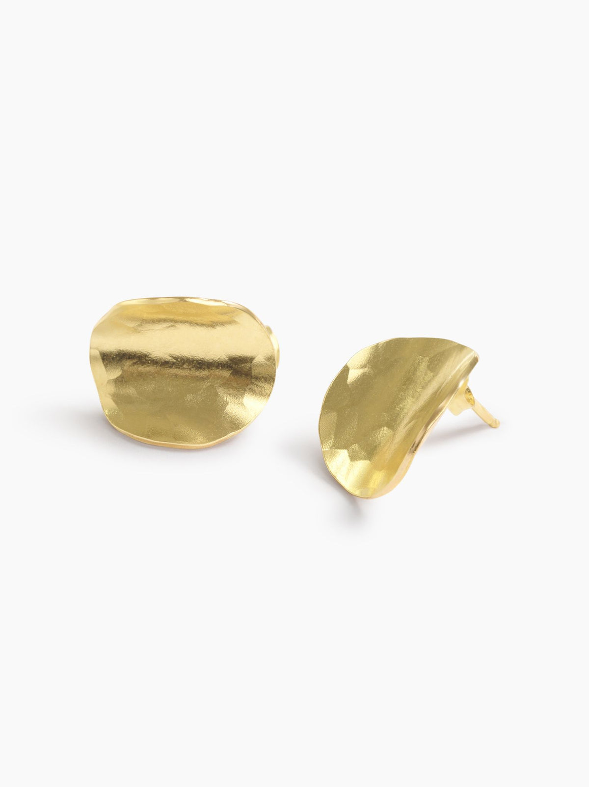 Side view of a pair of gold disc-like stud earrings on a white background.