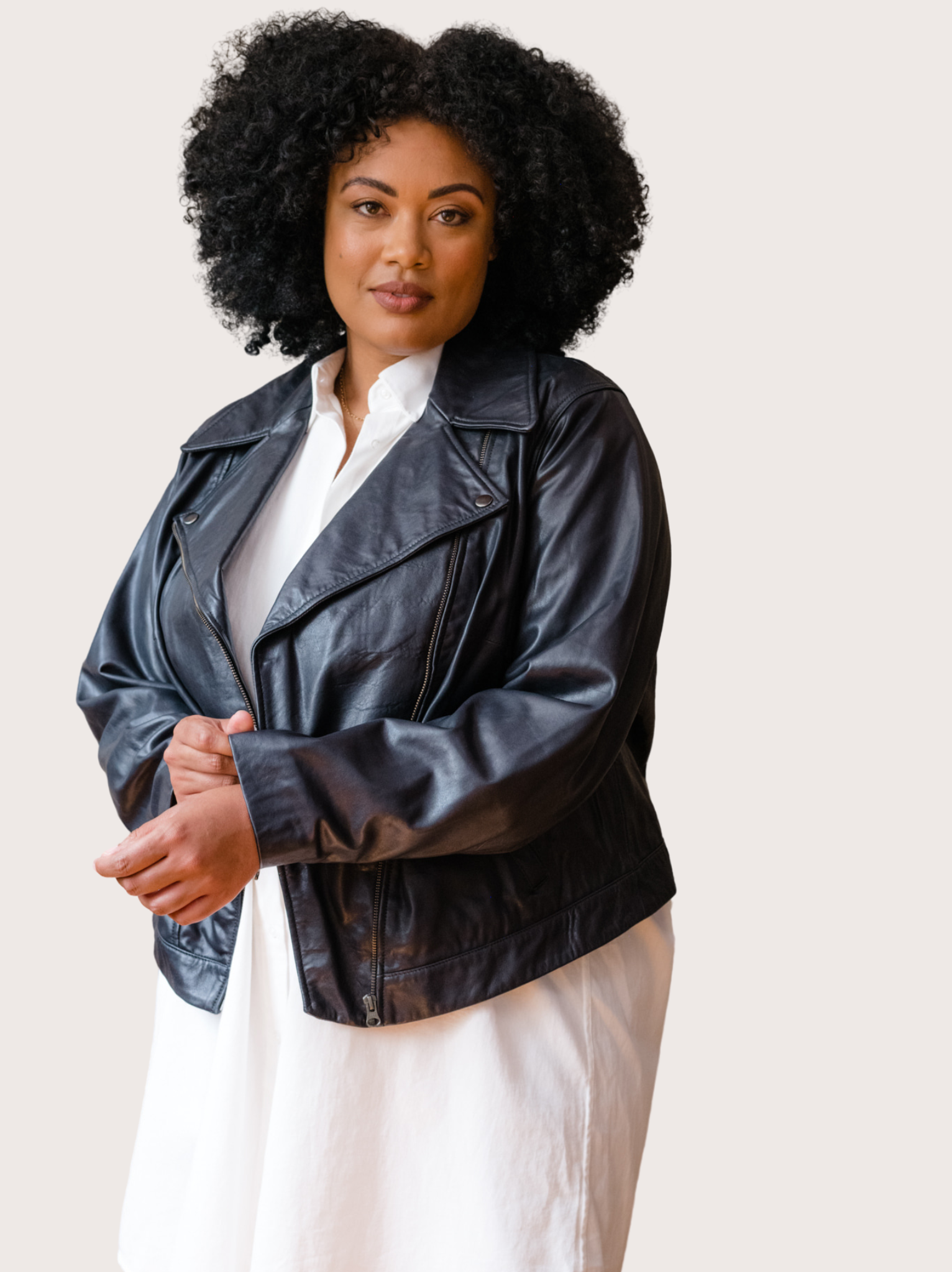 A woman wearing a black Maha Leather Jacket with a white shirt.