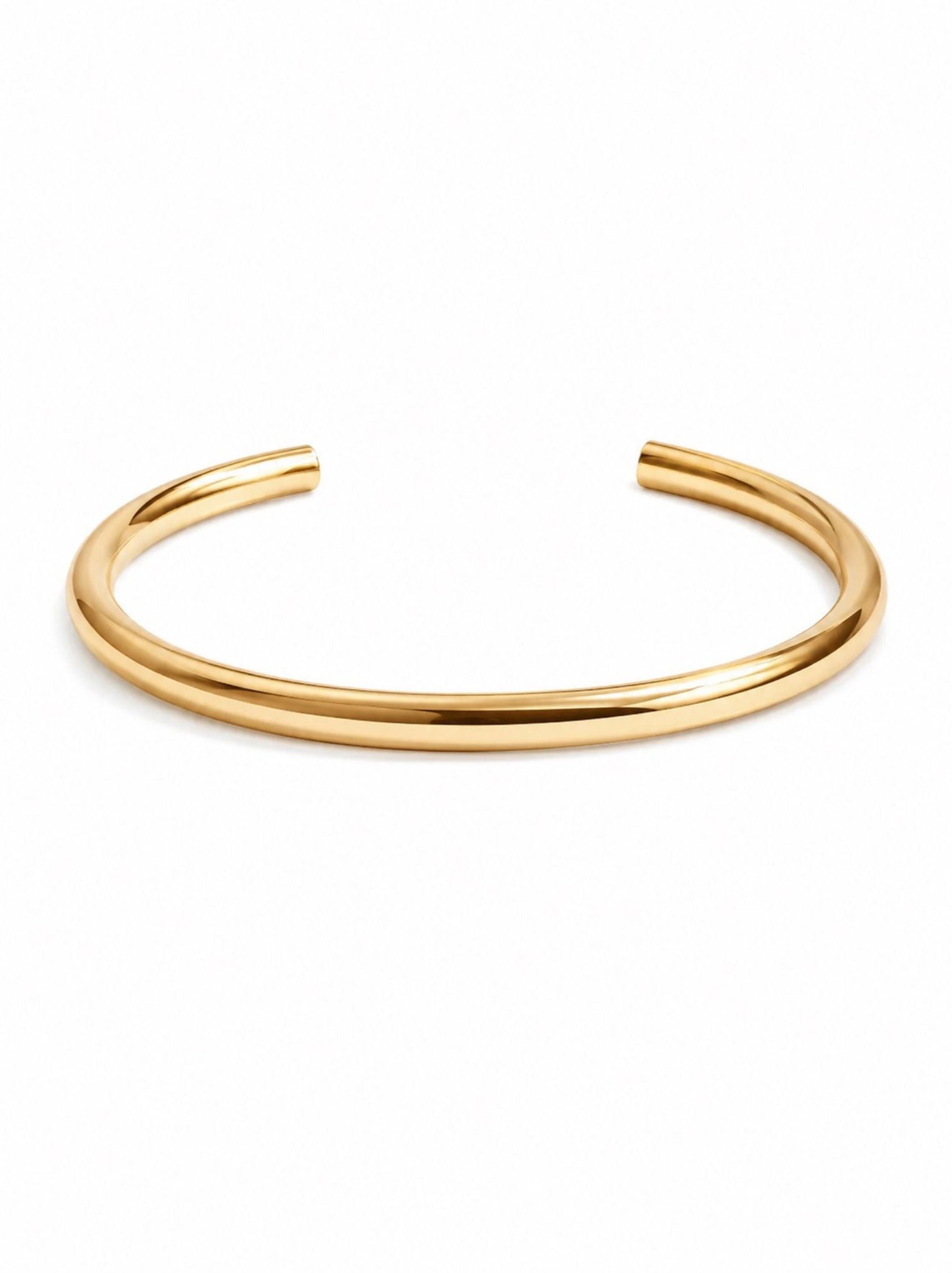 Thick gold cuff bracelet on a white background.