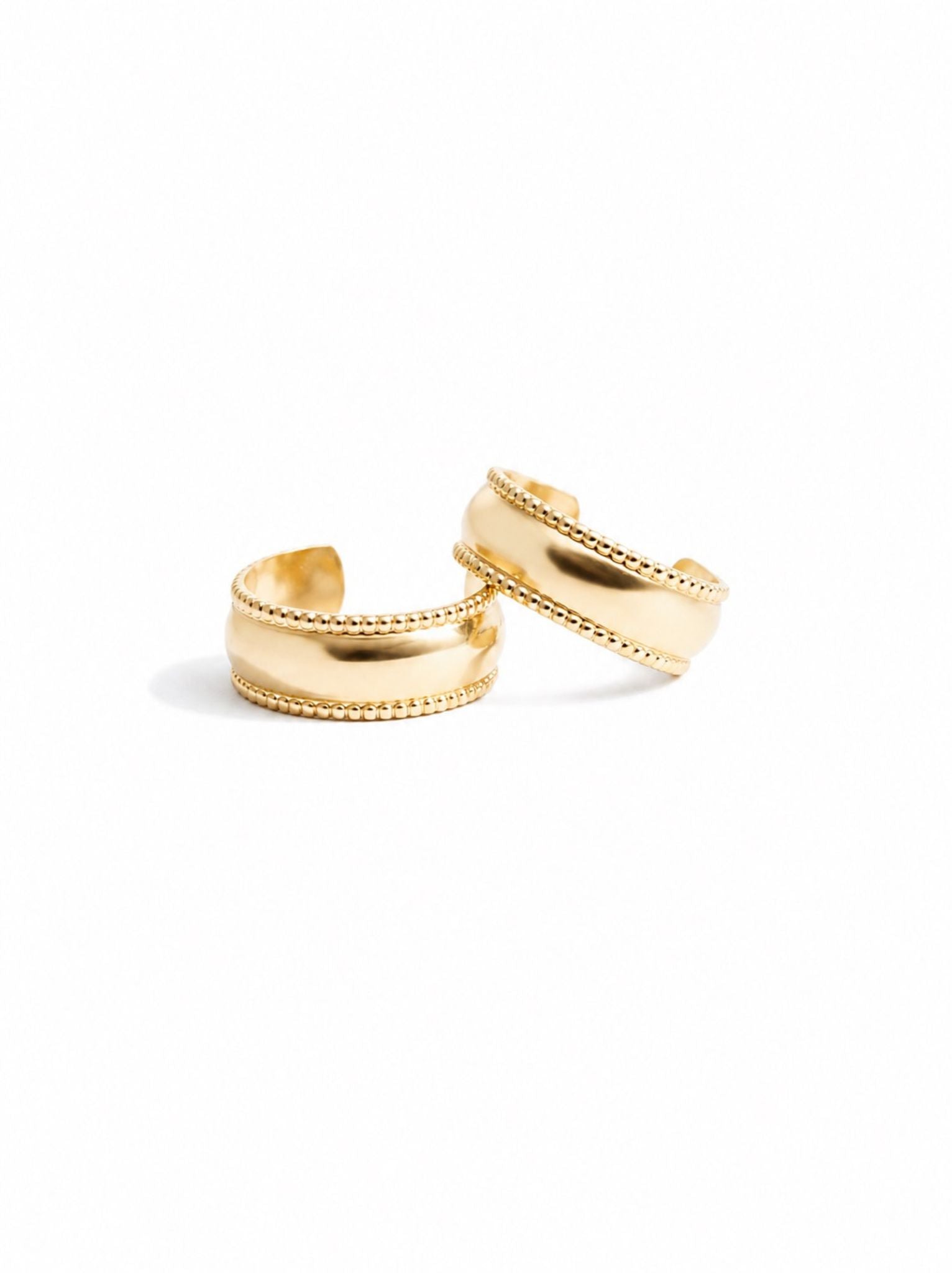 Two small gold hoop earrings lying on top of each other, showing their textured edges on a white background. #Color_14k Gold-filled