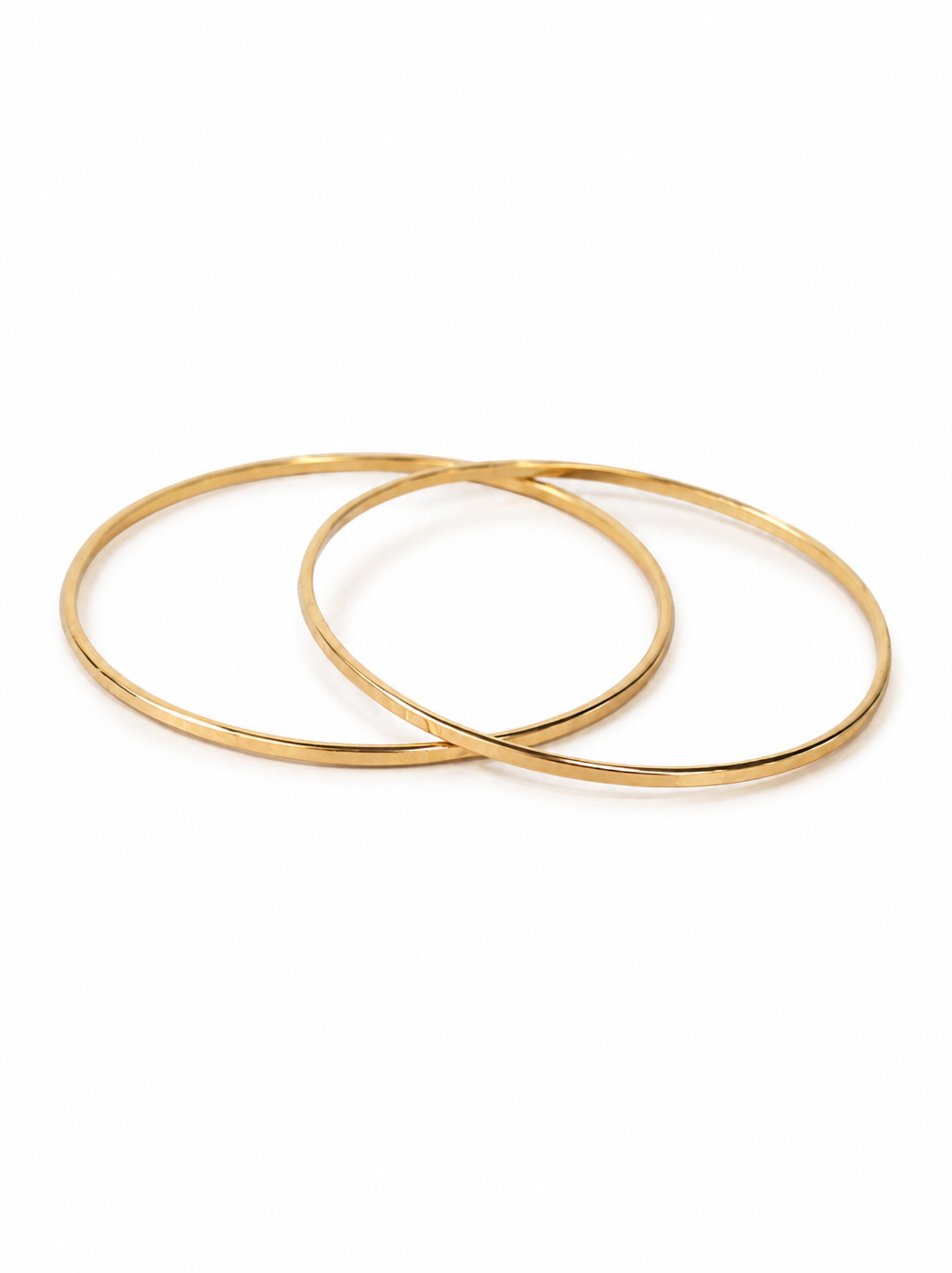 Two gold bangle bracelets on a white background.