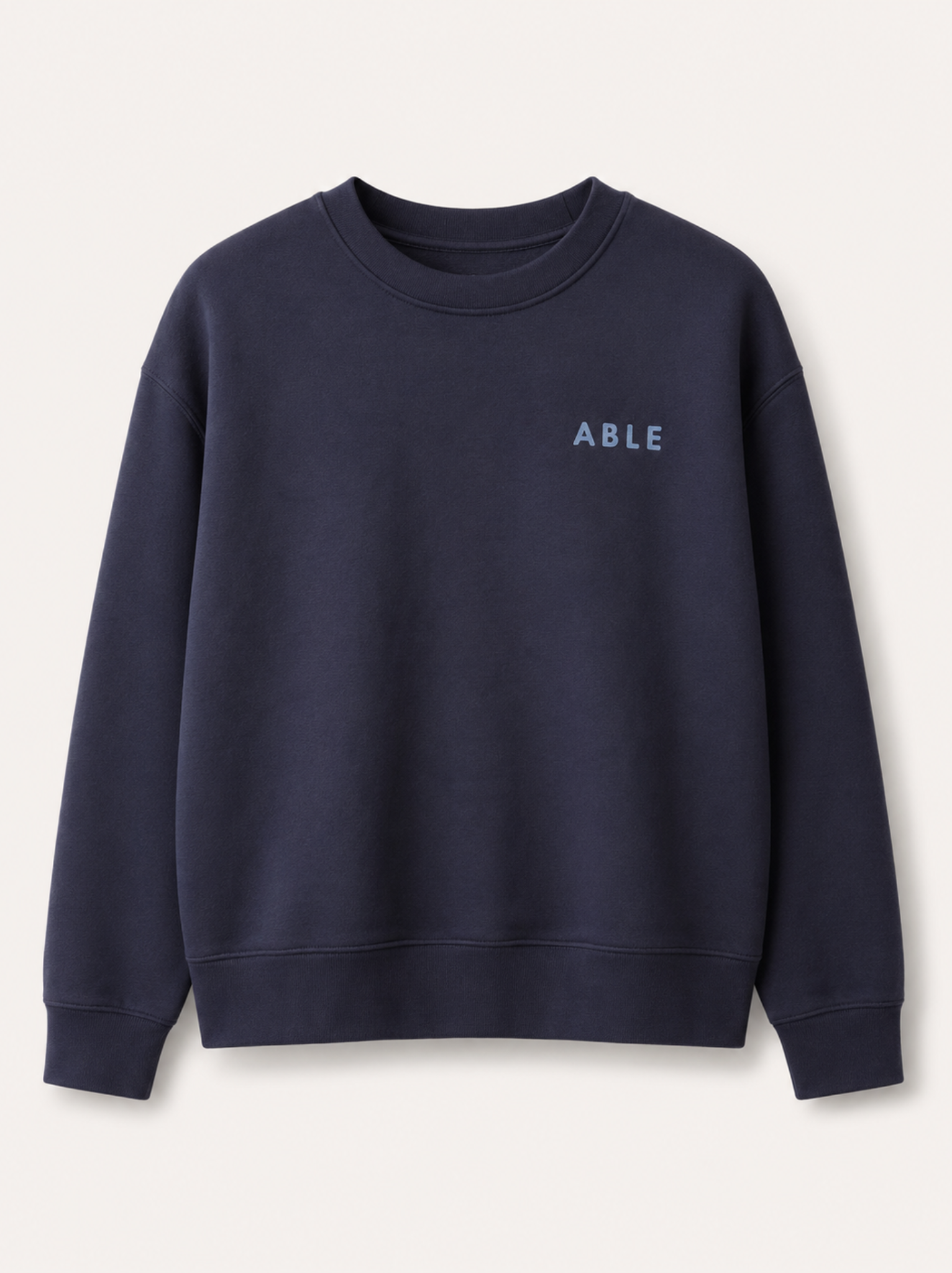 A navy blue crewneck sweatshirt with the word 'ABLE' printed in light blue on the left chest, displayed on a clean off-white background. #Color_Navy Ink