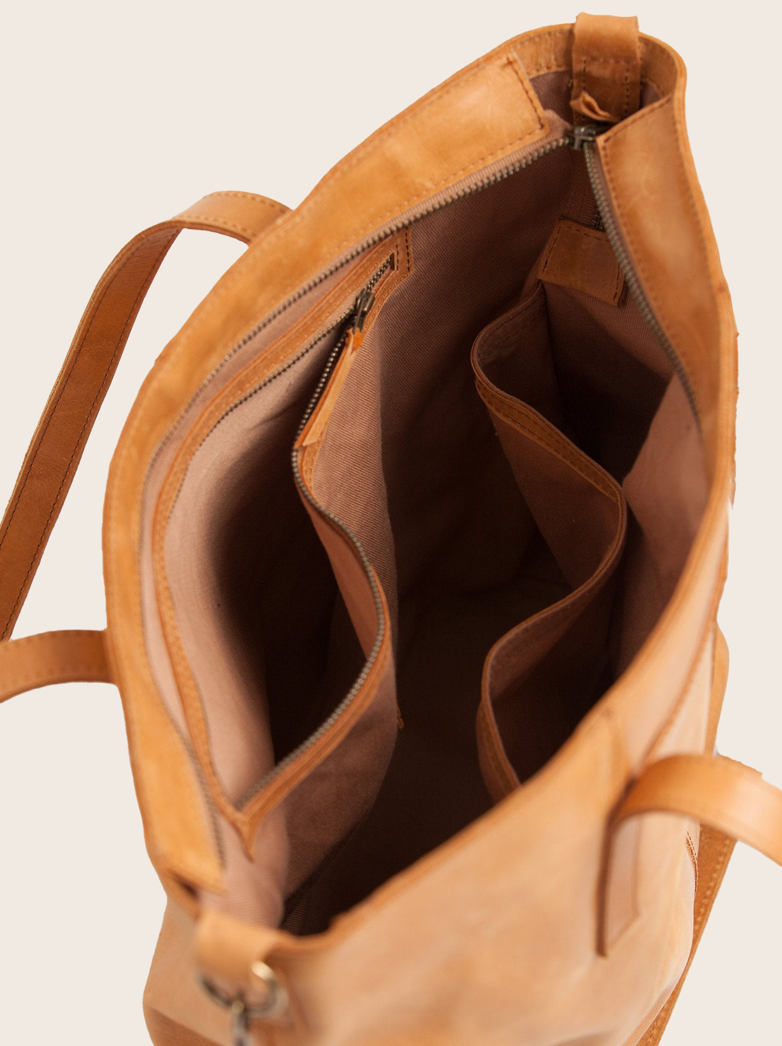 Lined interior of cognac utility tote bag with interior zip and slip pockets. #Color_Cognac