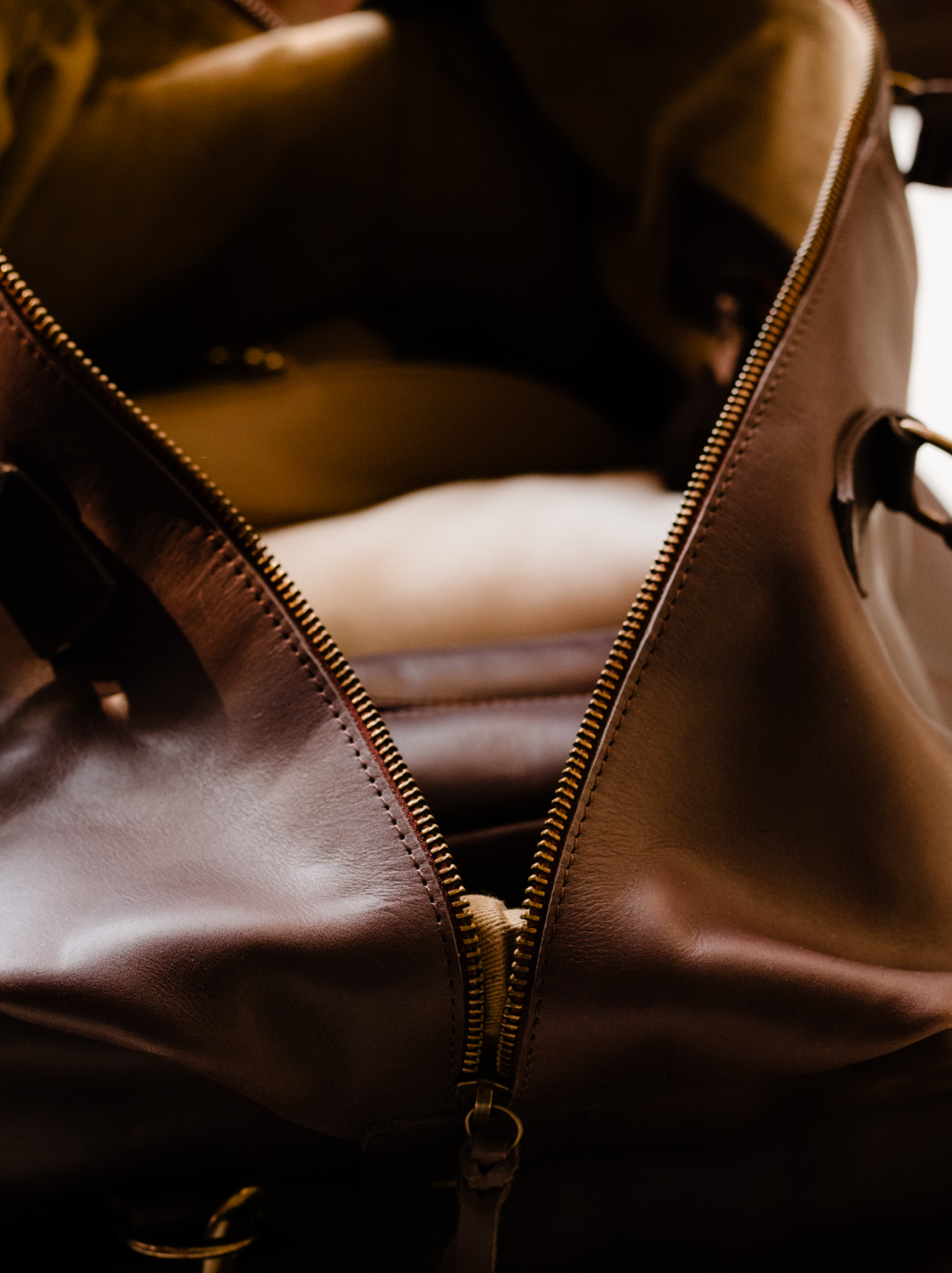 Close up of zipper thread of chocolate brown leather weekender bag. #Color_Chocolate Brown