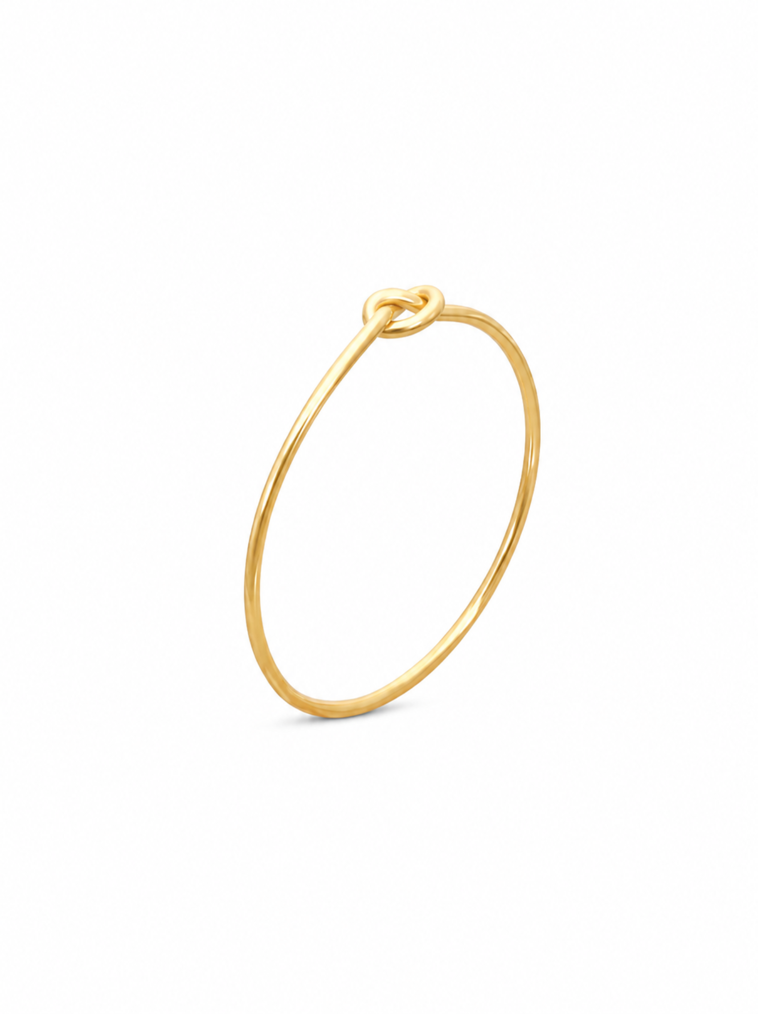 Side view of a gold ring with knotted detail standing up on white background.