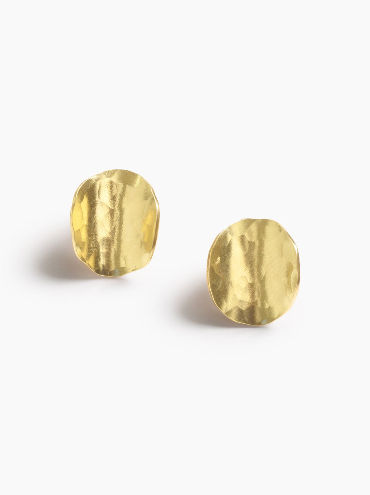 Pair of gold disc-like stud earrings, showing their hammered texture, on a white background.