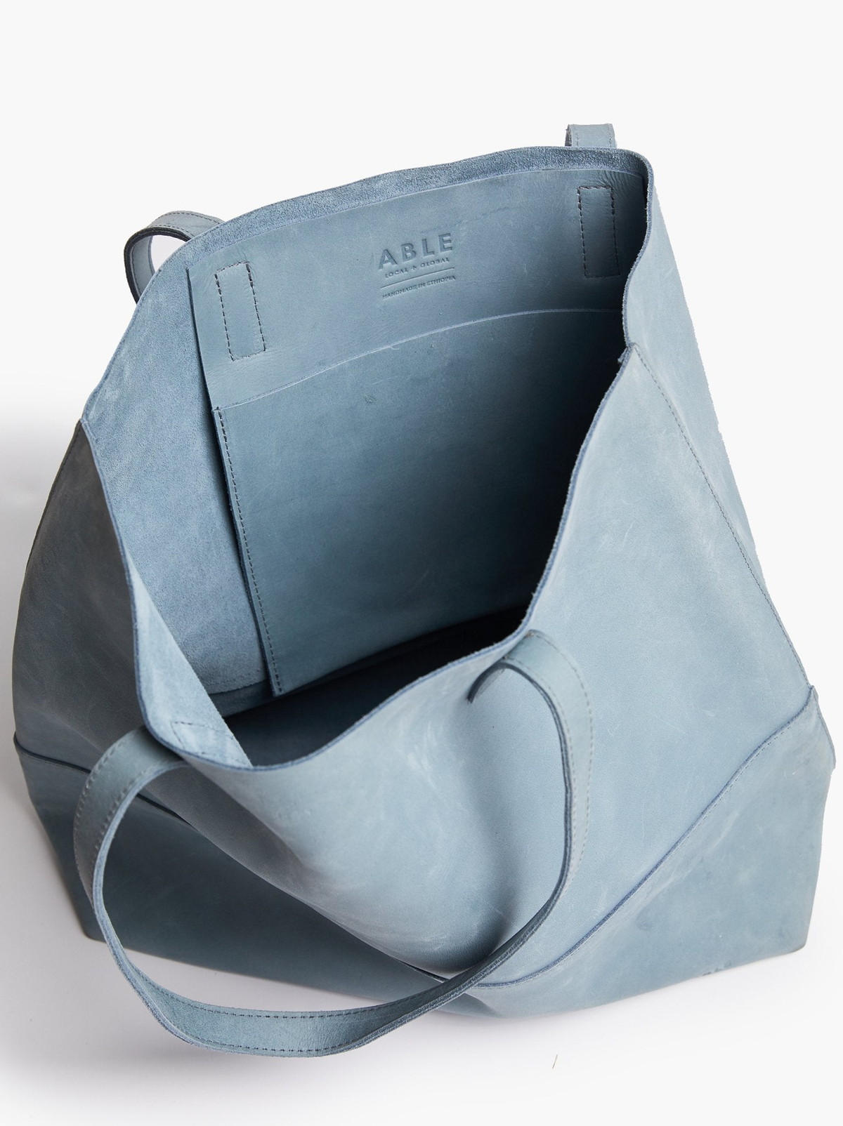Light blue tote interior shot with a visible brand name on a white background. #Color_Mist