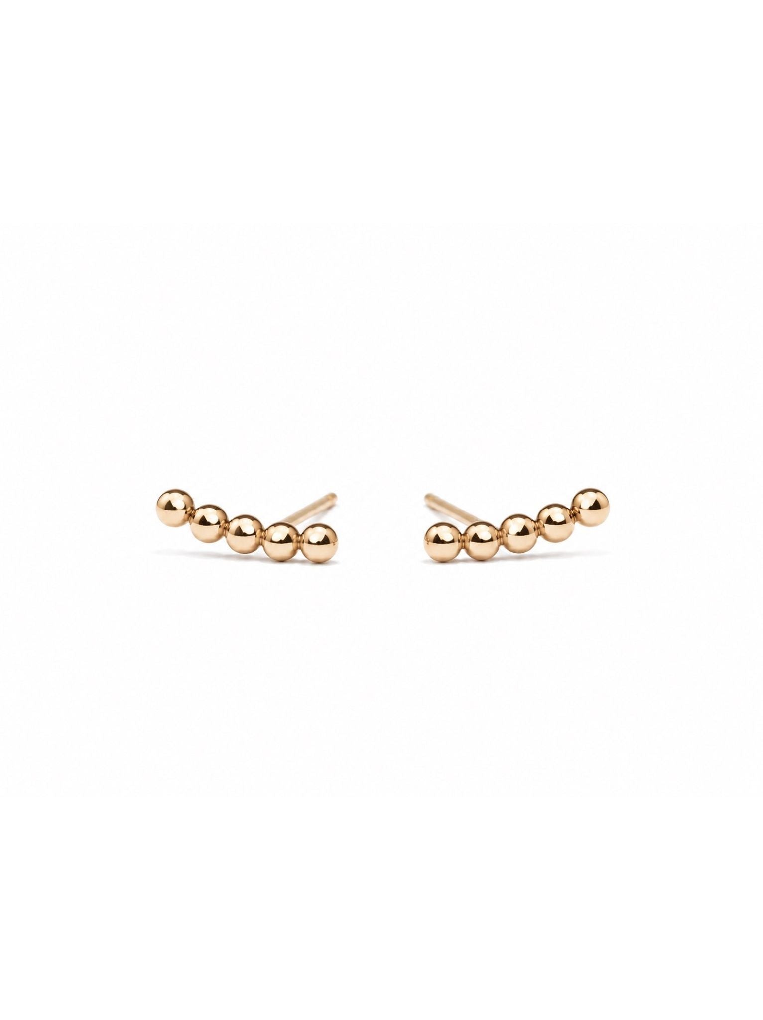 Pair of gold beaded detail bar earrings on a white background.
