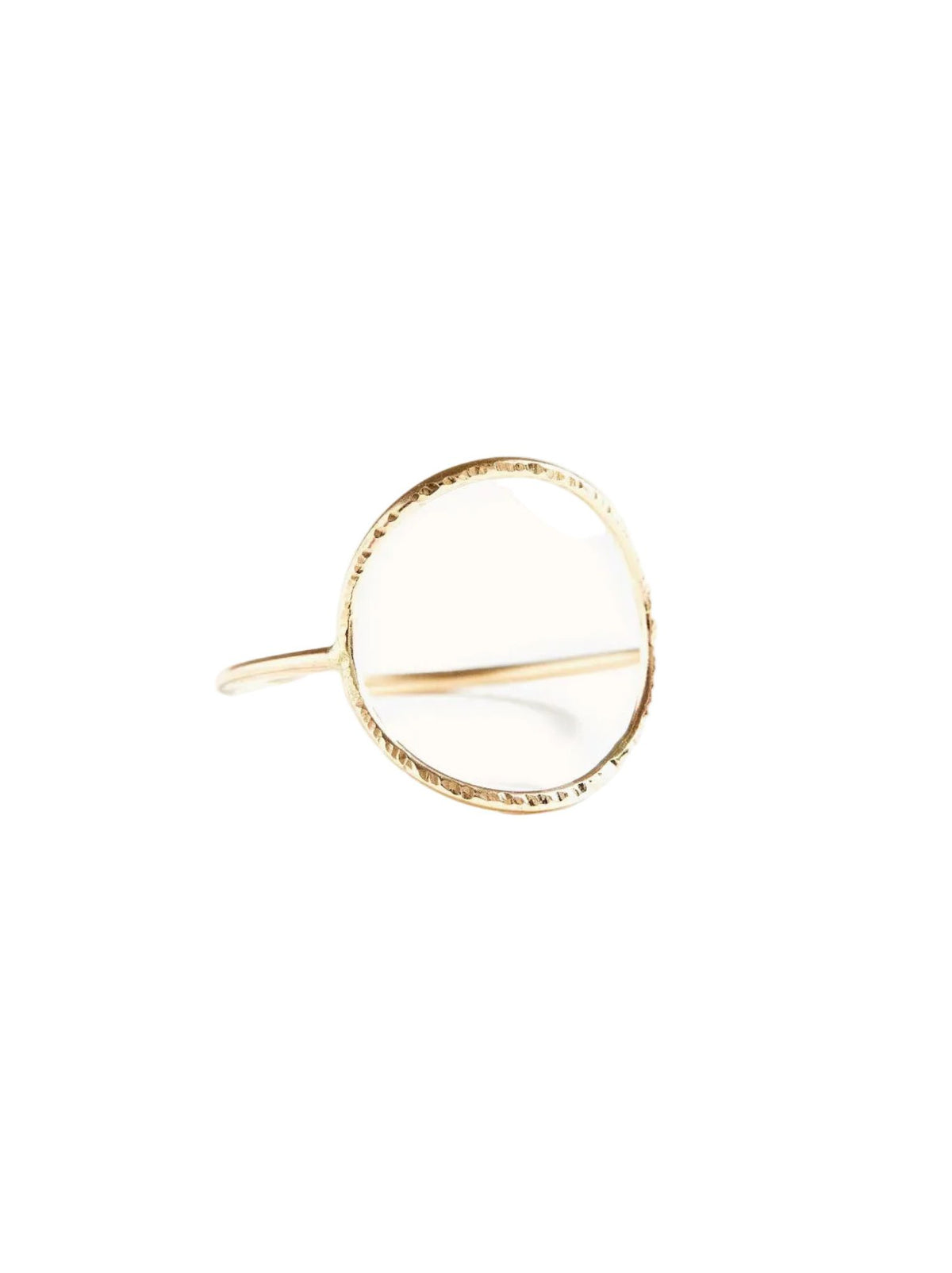 A delicate gold ring with a textured, hammered finish and a thin band, photographed on a clean, solid off-white background.