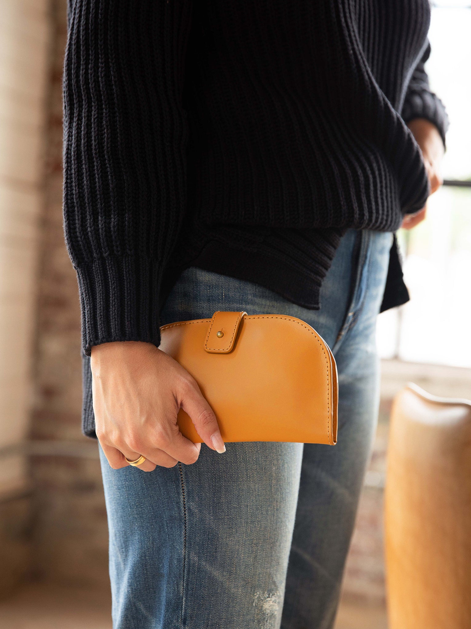 Woman holding Cognac bifold wallet #Color_Cognac